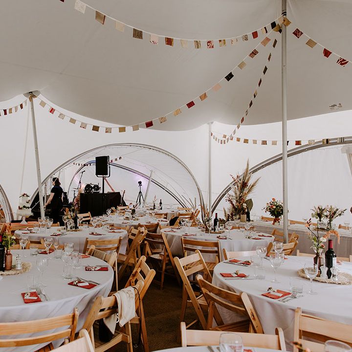Stretched tent with boho styling, DIY bunting and small floral arrangements 