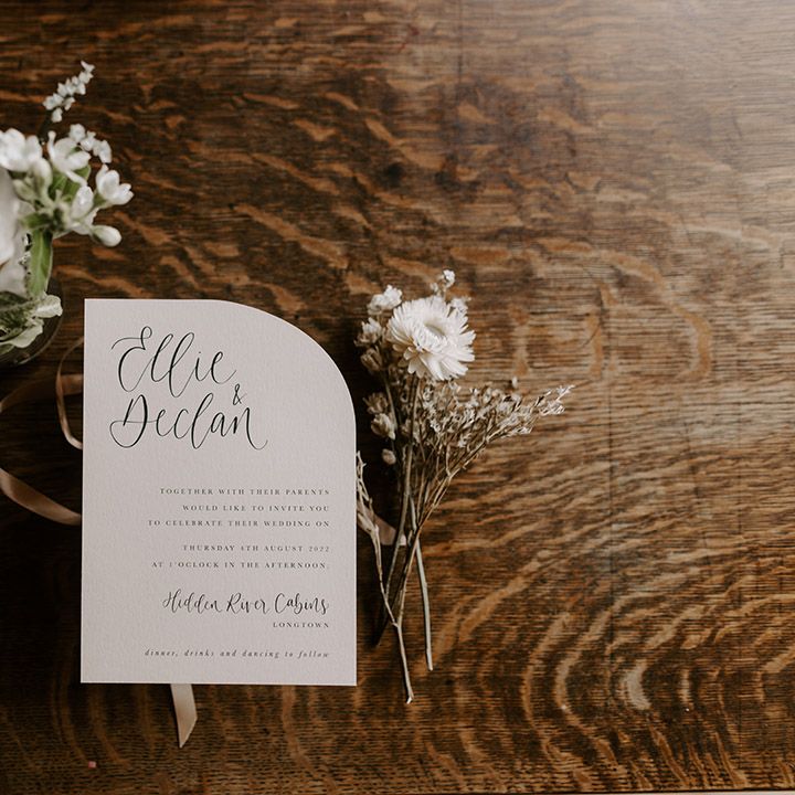 Simple and minimal wedding stationery wedding invitation on arched paper with white flower decor 