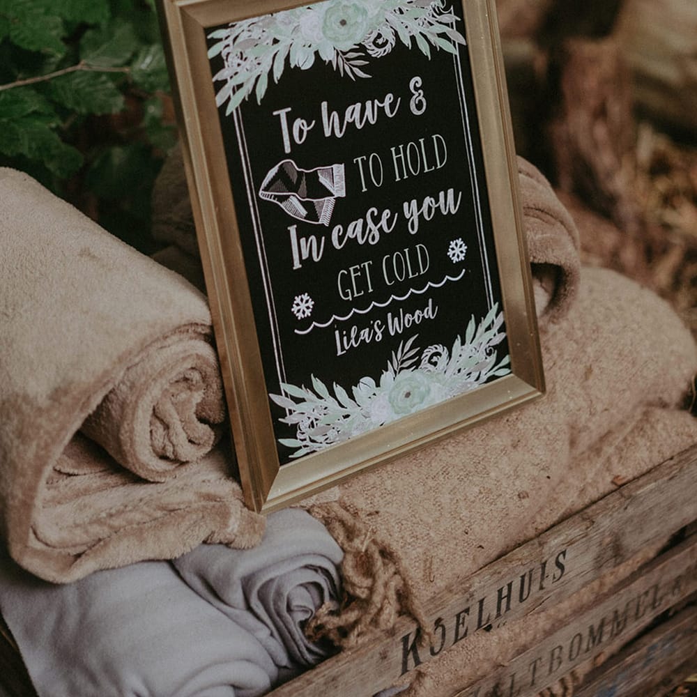 Chalkboard sign instructing guests to take a blanket wedding favour for outdoor woodland wedding 
