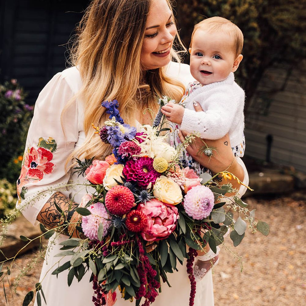 Bride with little baby holding wedding bouquet at botanical boho wedding day at The Parlour, Blagdon