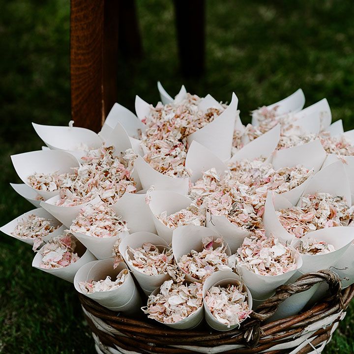 Confetti cones filled with dried petals in wicker basket 