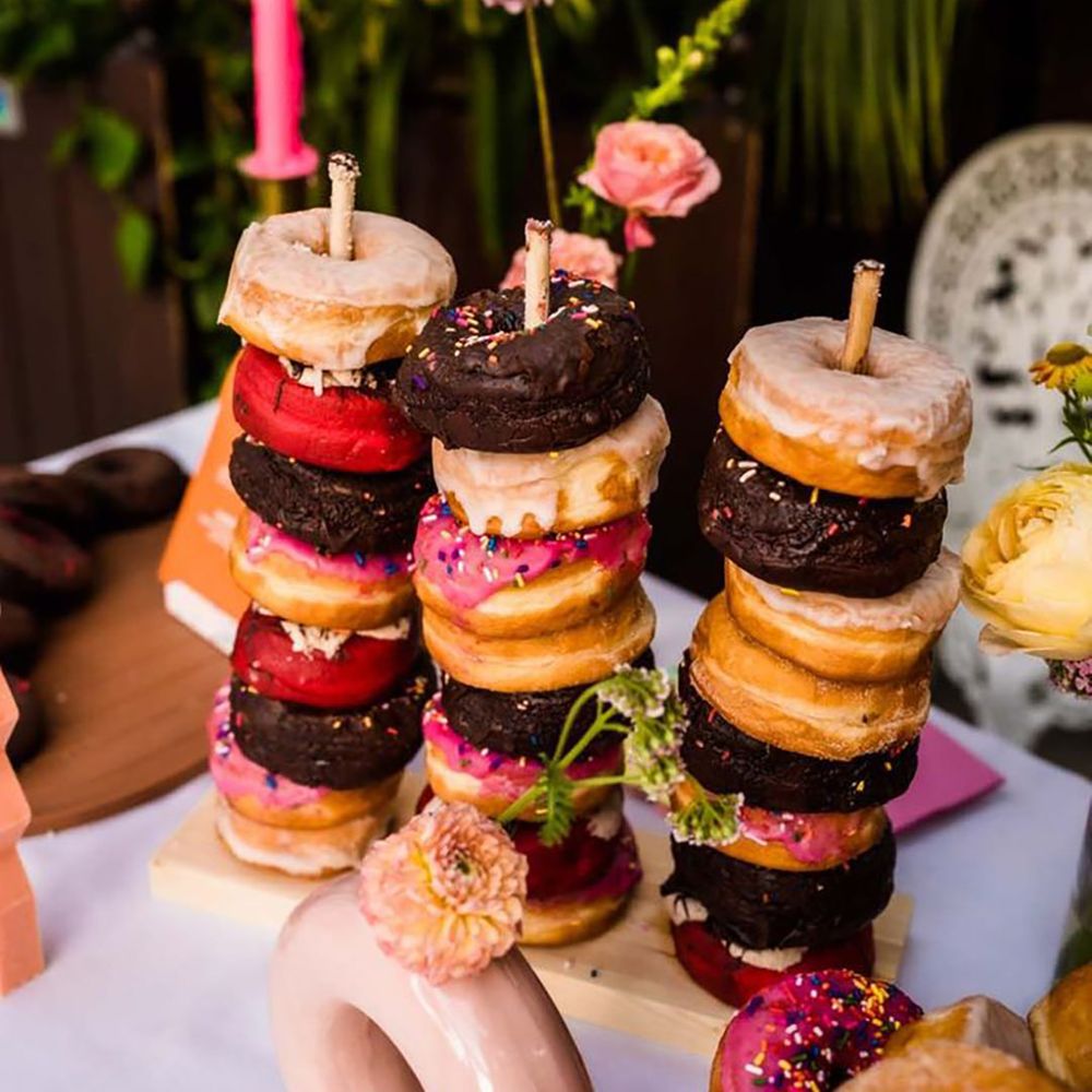 Doughnut tower with glazed doughnuts, chocolate doughnuts and pink sprinkle doughnuts 