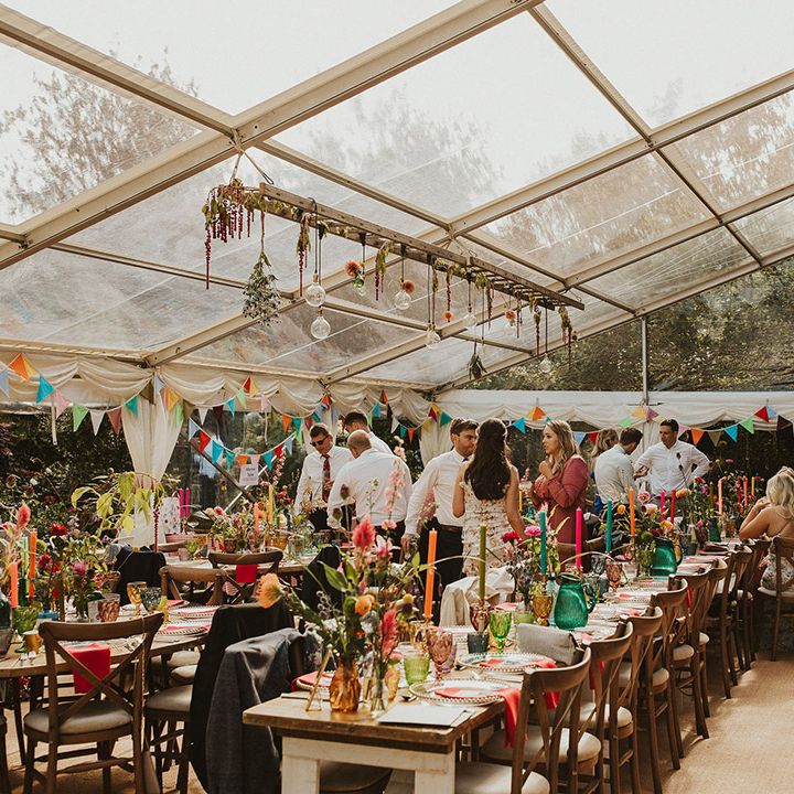 colourful back garden clear marquee wedding reception with vibrant decor 
