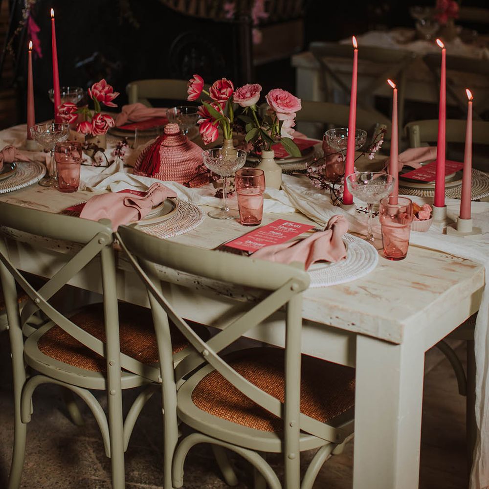 wedding reception table decor with coloured glass goblets, taper candles and wicker place mats 