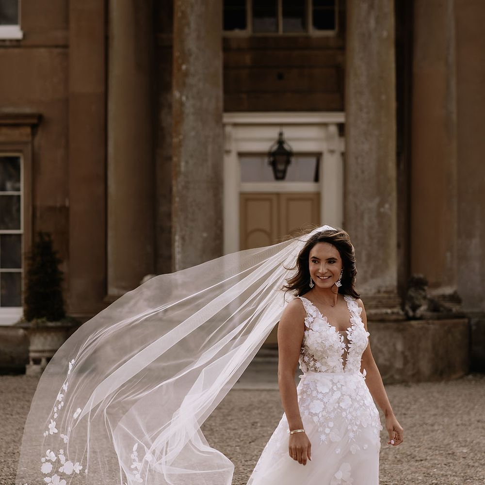 Bride in Mira Zwillinger floral applique wedding dress with flower embroidered veil 