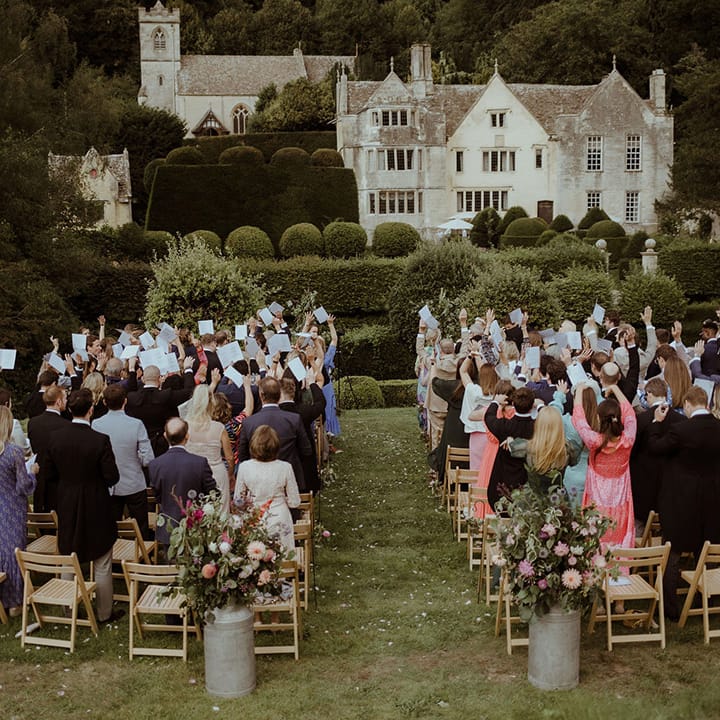 Wedding guests raise their hands for the handfasting ceremony 