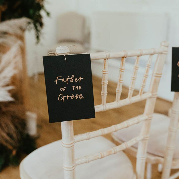 Black and gold tags with names and titles on to reserve the chairs 