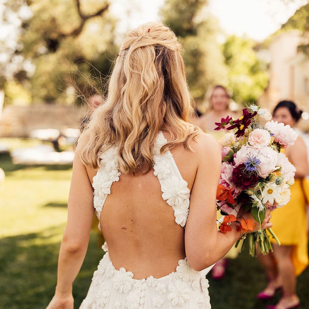 Bride in a flower Emma Beaumont wedding dress with a halter back style 