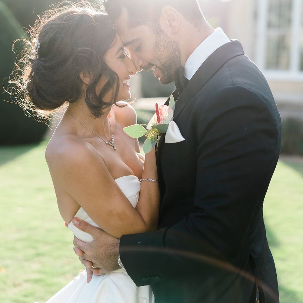 Bride & groom embrace outdoors as the sun shines around them at Syon Park