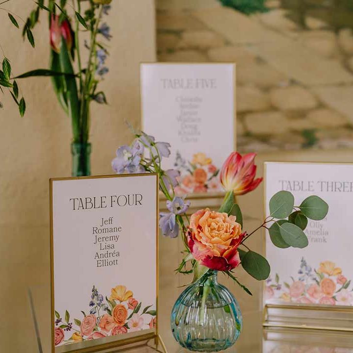 Botanical luxe floral wedding table numbers and bright blue glass bottles with dried flowers
