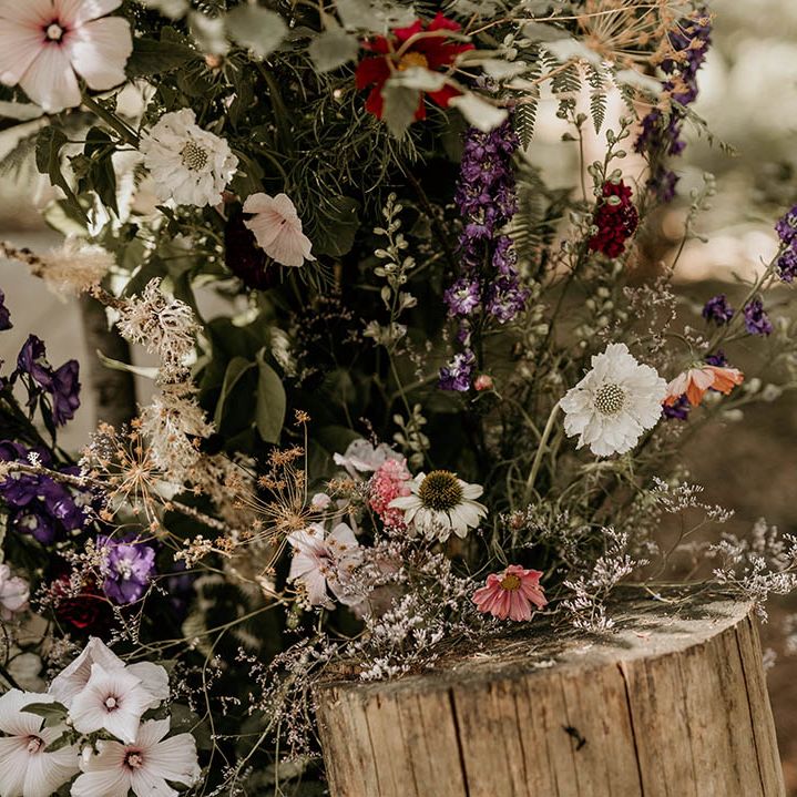 Purple and white wedding flowers decorating the woodland wedding venue 