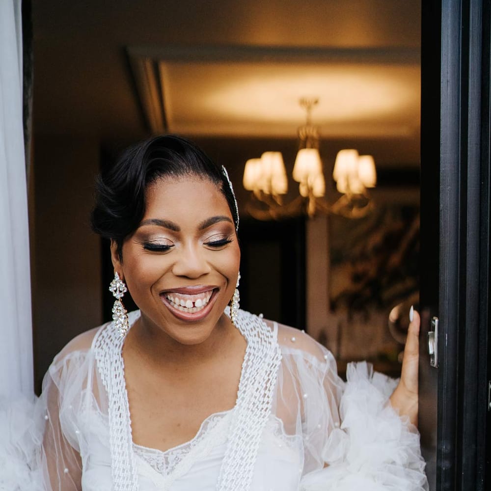 Bride in white sheer tulle and pearl bridal getting ready robe and silver sparkly bridal jewellery 