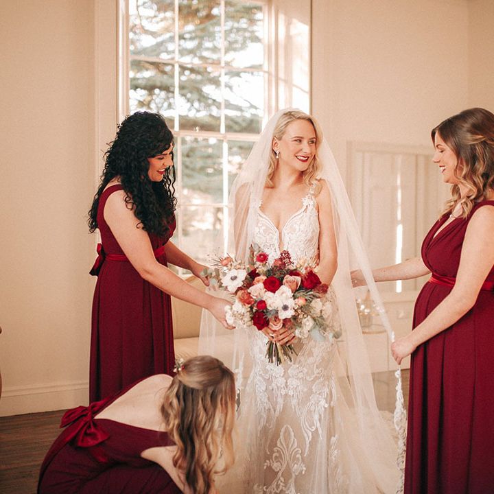 Bridal party wearing red bridesmaid dresses for winter wedding in December 