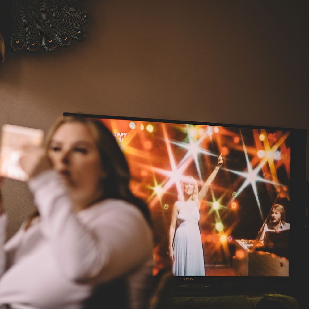 Bride looks in mirror as she applies makeup on the morning of her wedding