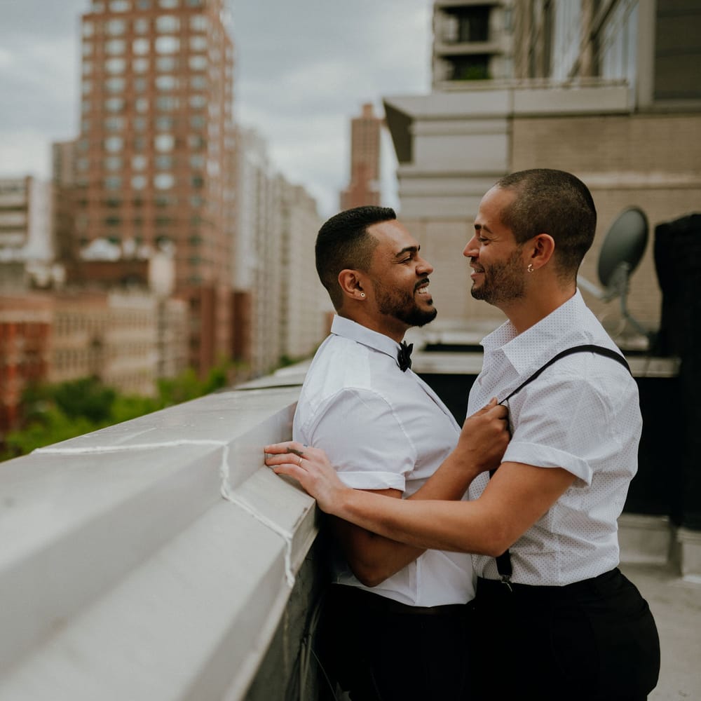 Grooms share an intimate moment at rooftop wedding