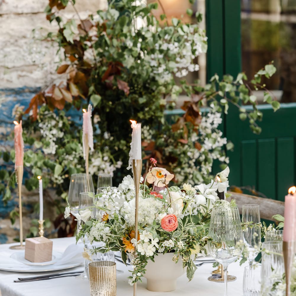 wedding table decor with gold candlesticks and floral centrepiece 