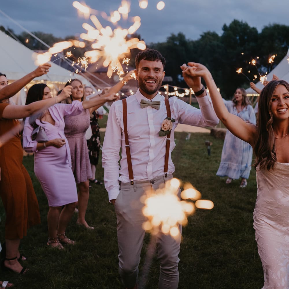 Bride & groom walk through sparklers held by wedding guests on their wedding day | Mark Bamforth Photography