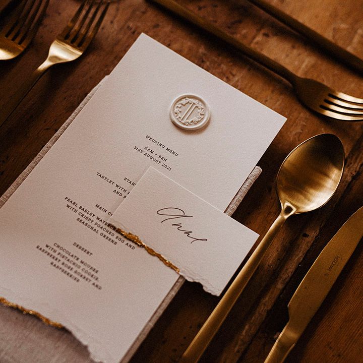 Wedding menu card with ripped edge with gold edges and wax seal with gold cutlery