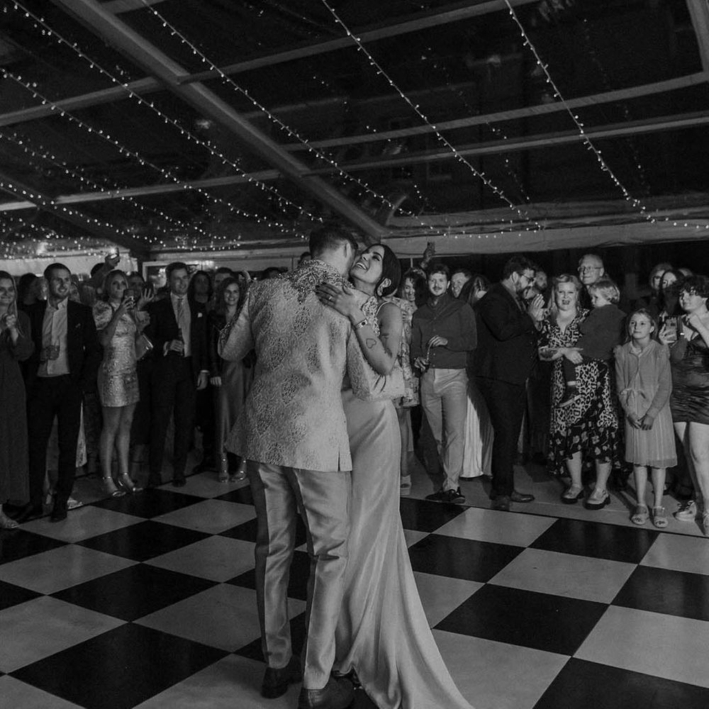 Bride and groom first dance in a clear glass marquee wedding reception 