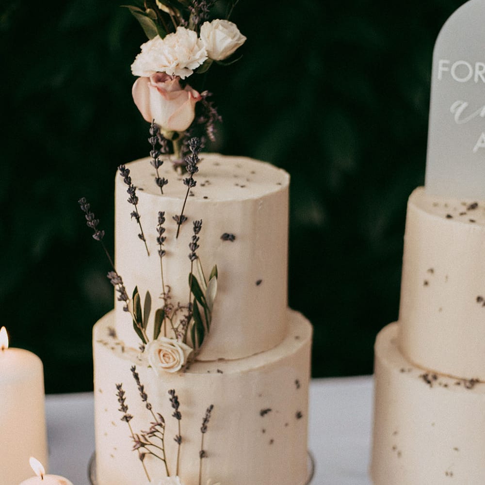 Two tier buttercream wedding cake with dried lavender and white rose decorations 