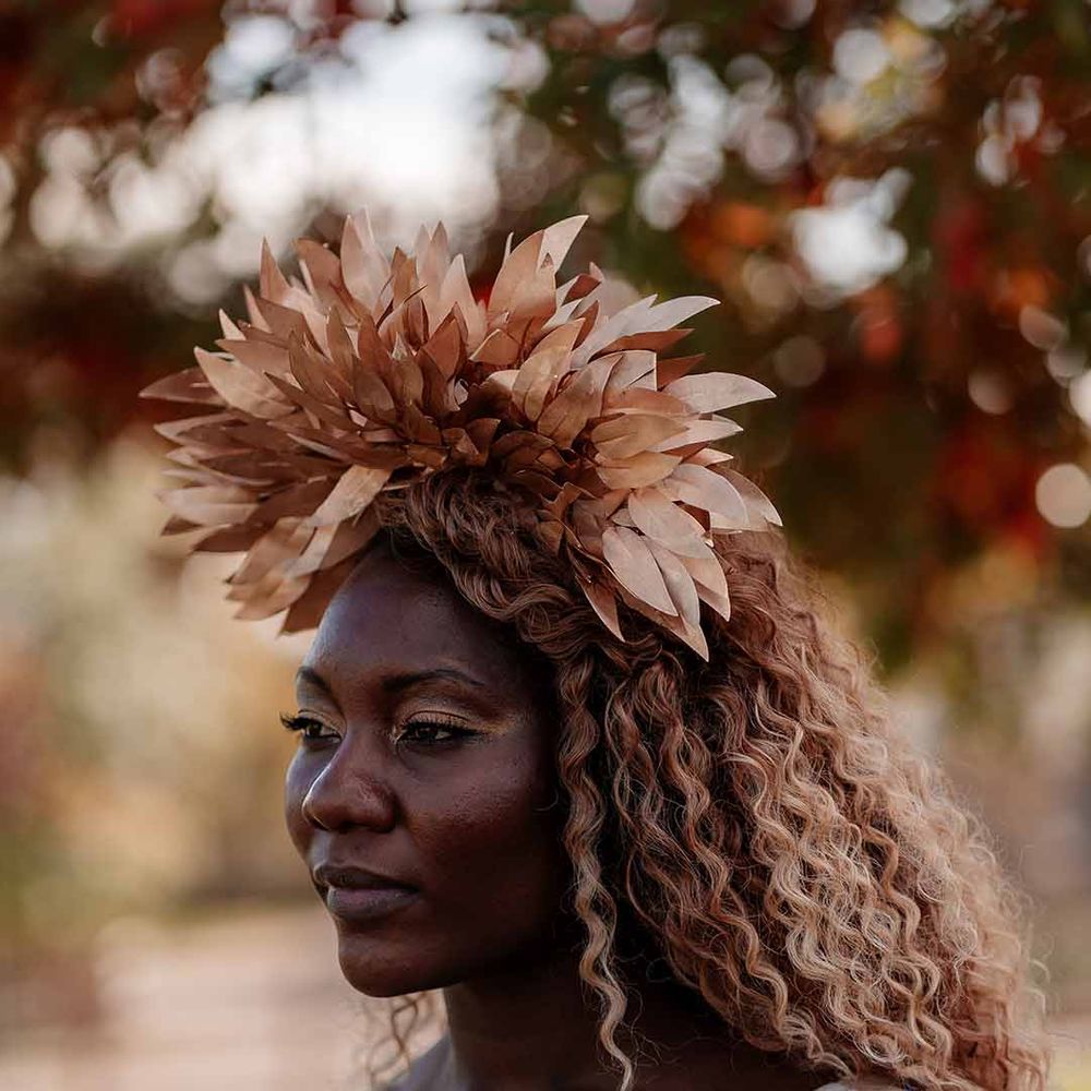 Bride with big, bold, golden eyeshadow and dewy lipstick wearing large golden leaf bridal crown