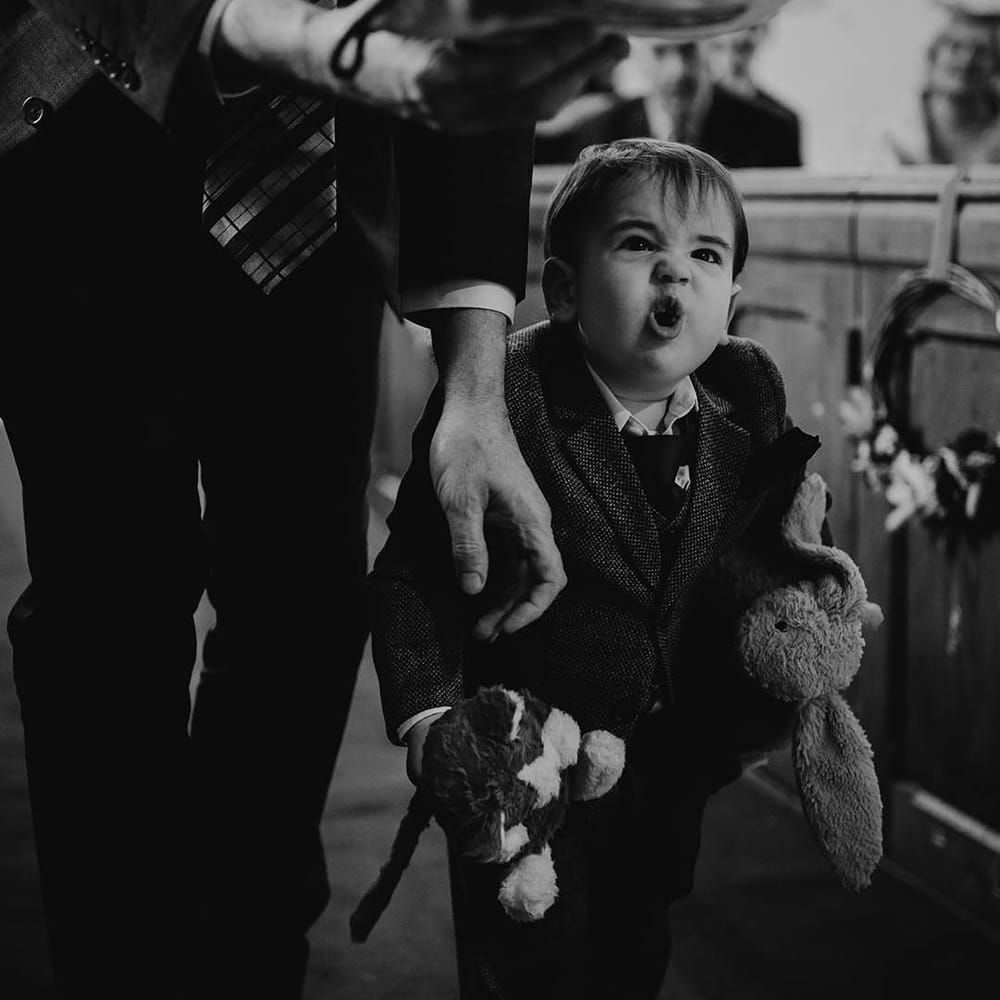 The bride and groom's little boy walking down the aisle with teddy bears 