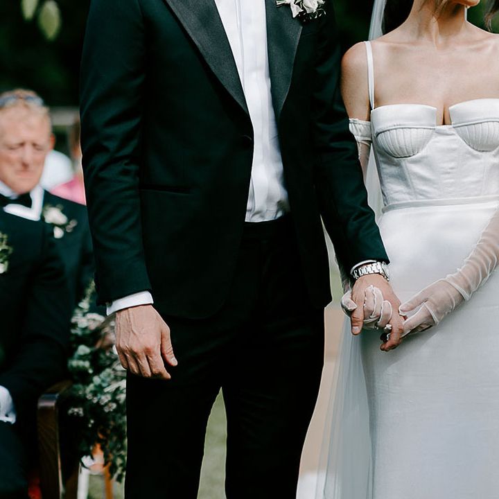Bride holding hands with the groom at the outdoor ceremony 
