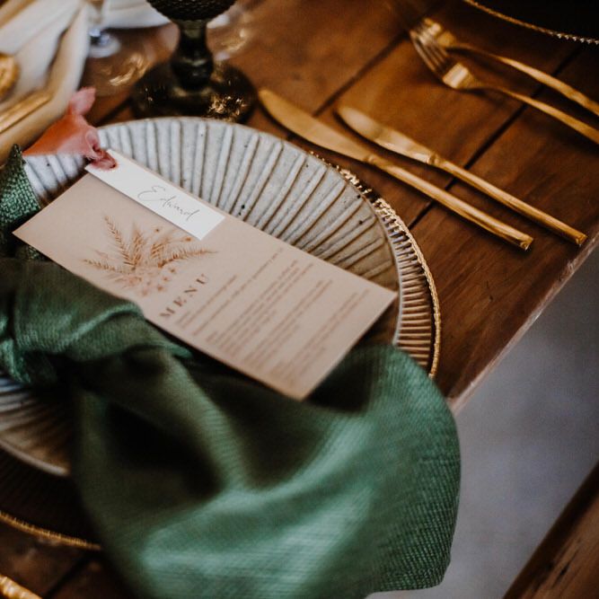 Emerald green napkins, gold cutlery and white and gold dinner plates