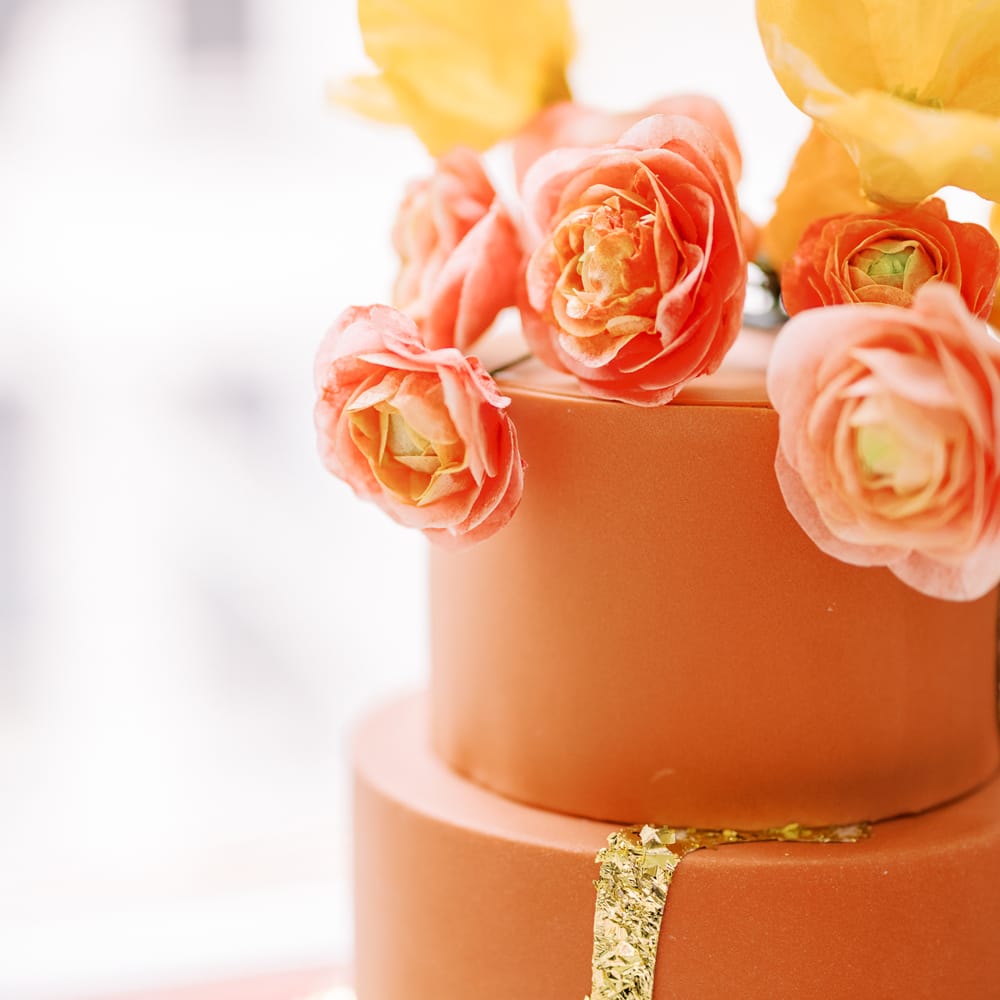 Orange wedding cake with floral decor