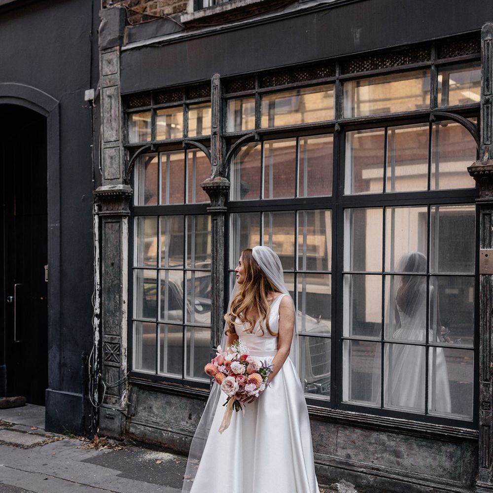 City city wedding with bride in a Karen Willis Holmes princess wedding dress holding a blush pink bridal bouquet 
