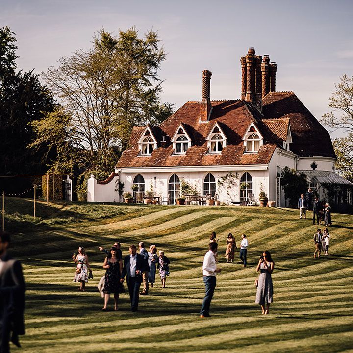 Wedding guests walk around and mingle at Houghton Lodge wedding venue 