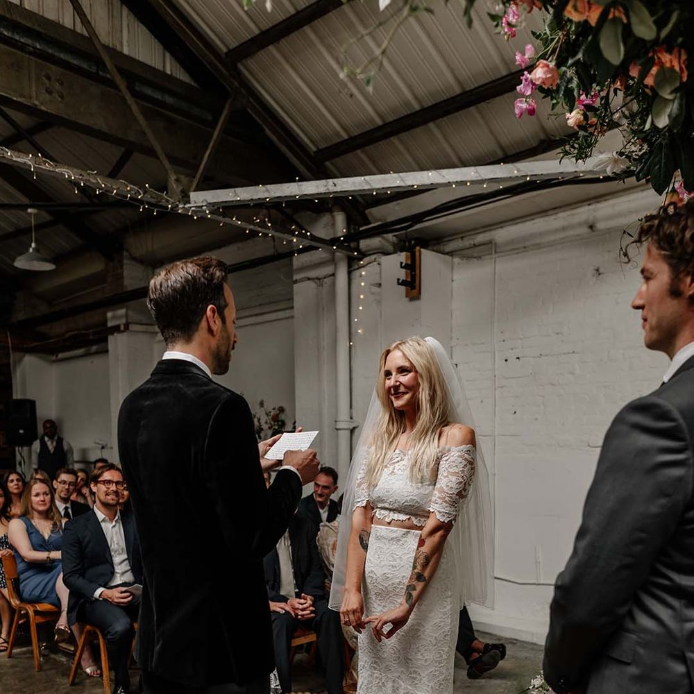 Bride in lace boho two piece with tattoos and groom in black tux with bow tie and boutonniere
