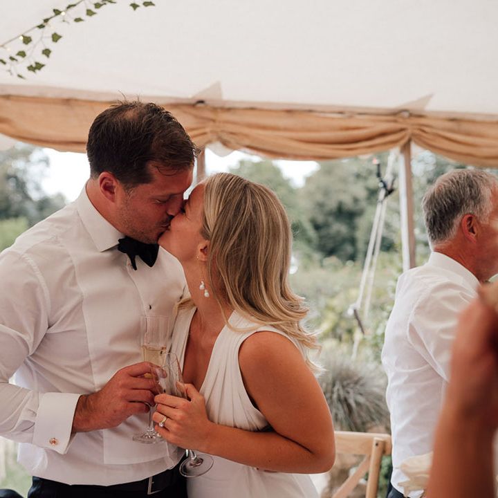 The bride and groom share a kiss and moment together on their wedding day at Pythouse Kitchen Gardens wedding venue 