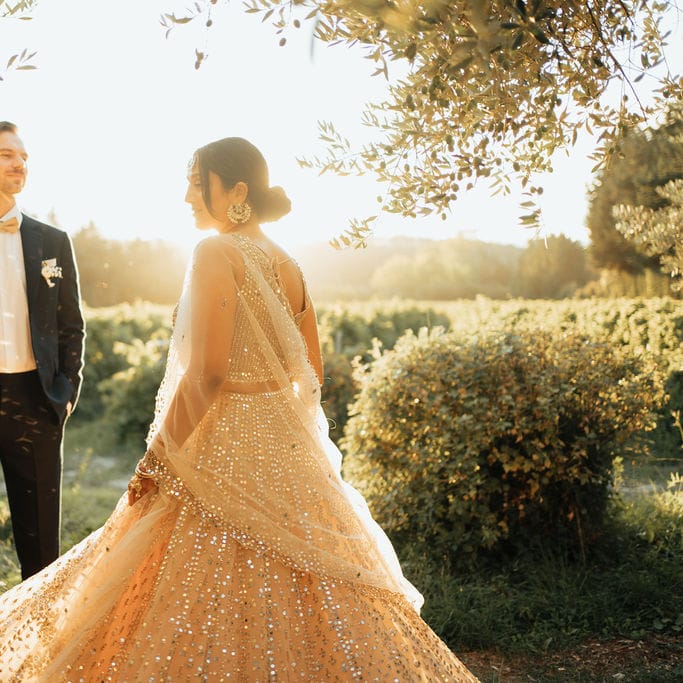 Groom in a black tuxedo twirling his bride in a sparkly wedding dress at their destination wedding 