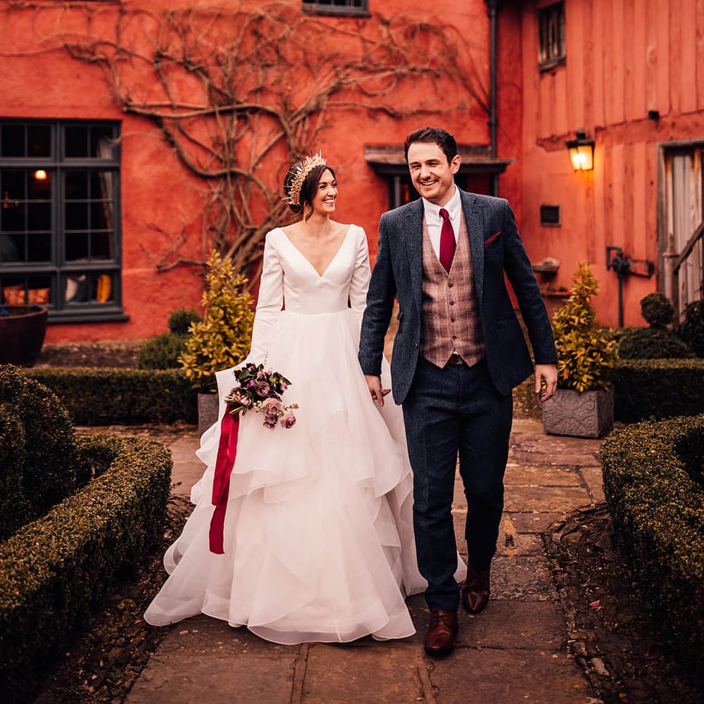 Pauntley Court country house wedding venue with the bride in a Morilee wedding dress and groom in three piece suit 