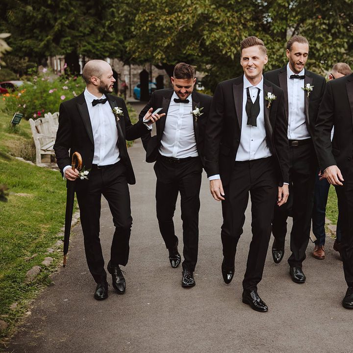 Groomsmen in black tuxedos for traditional wedding 