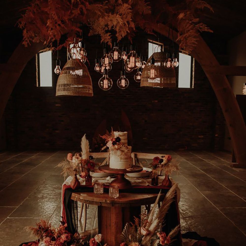 Moody and ambient sweetheart wedding dessert table with pampas grass and pink flowers with rustic wedding cake 