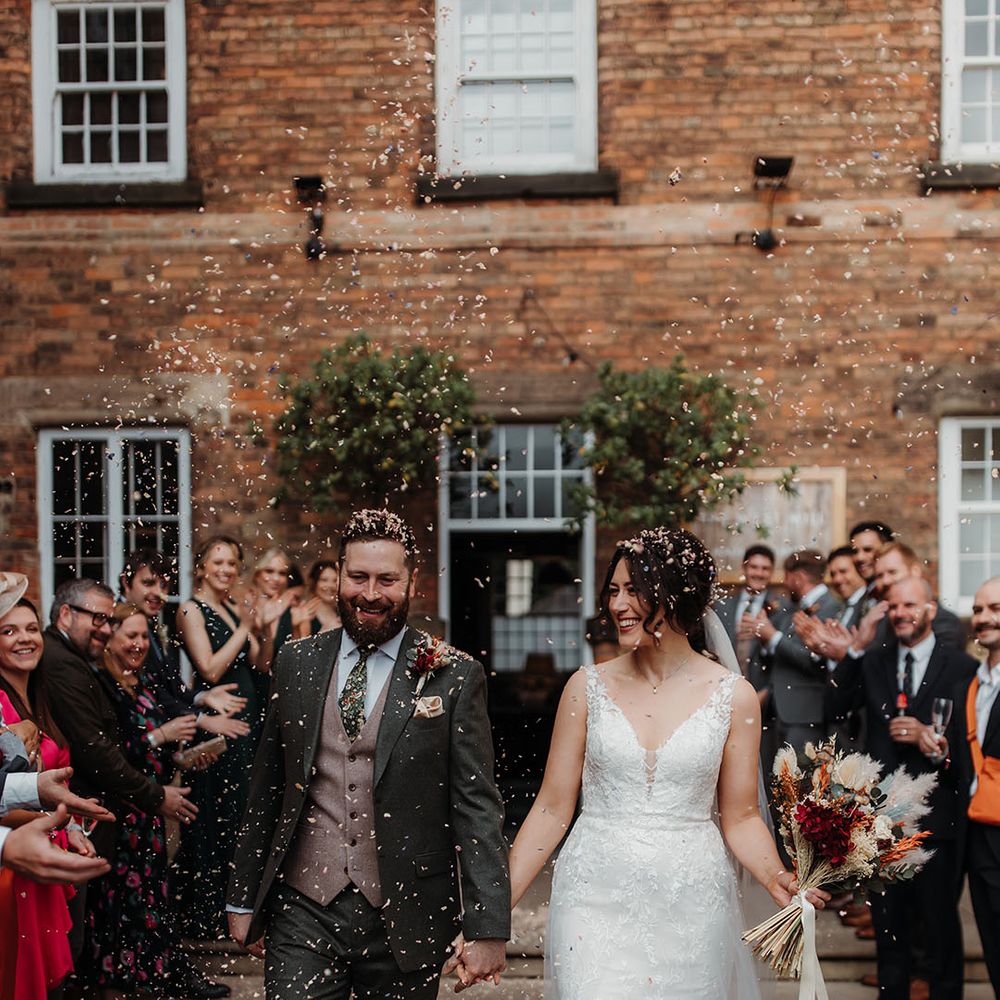 Confetti shot of the bride and groom at their industrial style wedding 