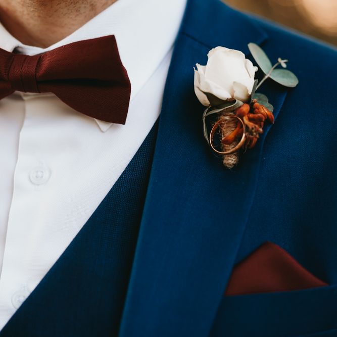 Navy suit and burgundy bow tie
