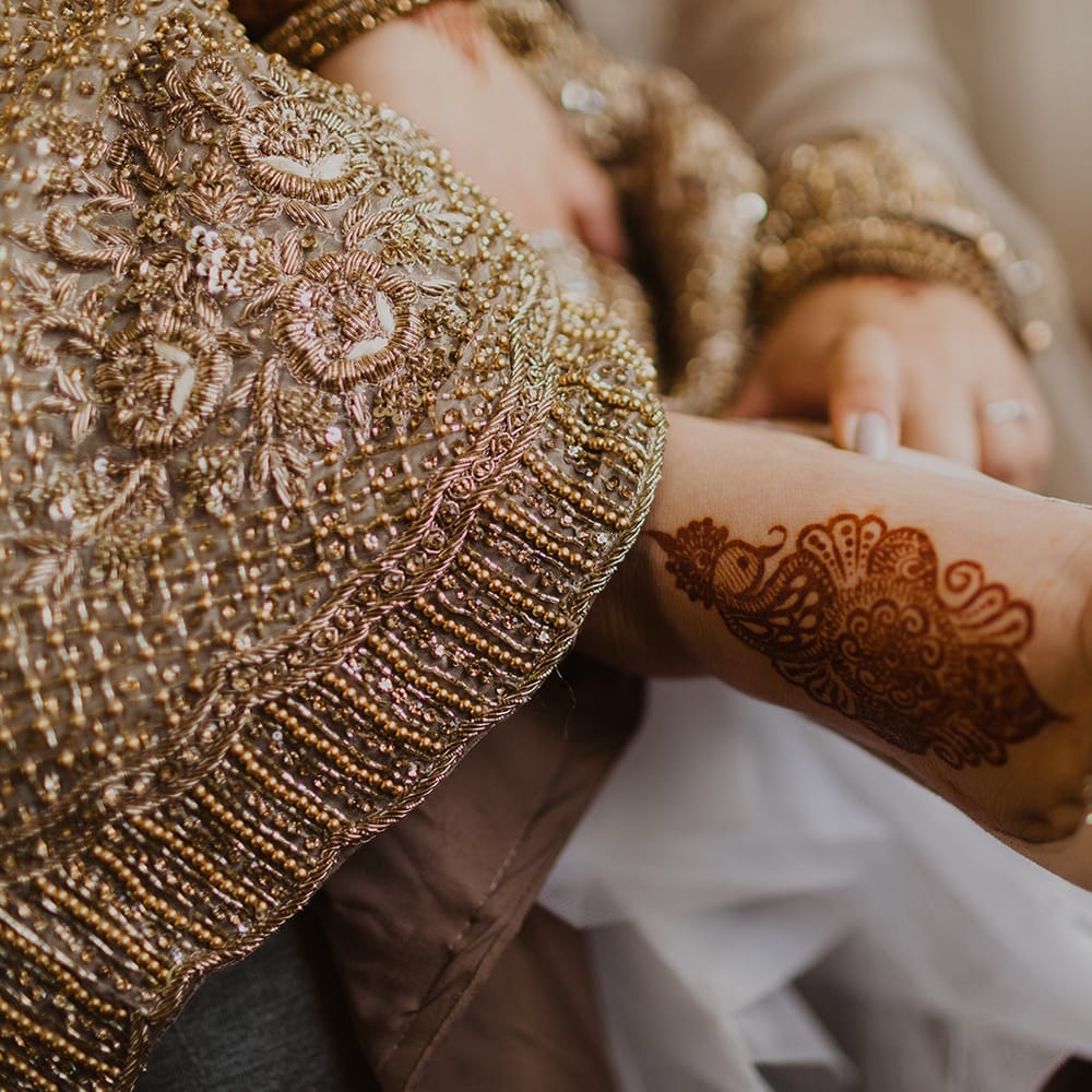 Bride putting on her shoes with henna on her feet 