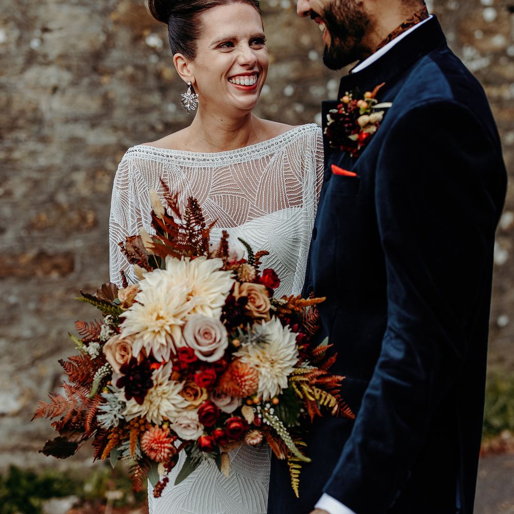Bride & groom together outdoors with Autumnal bouquet 