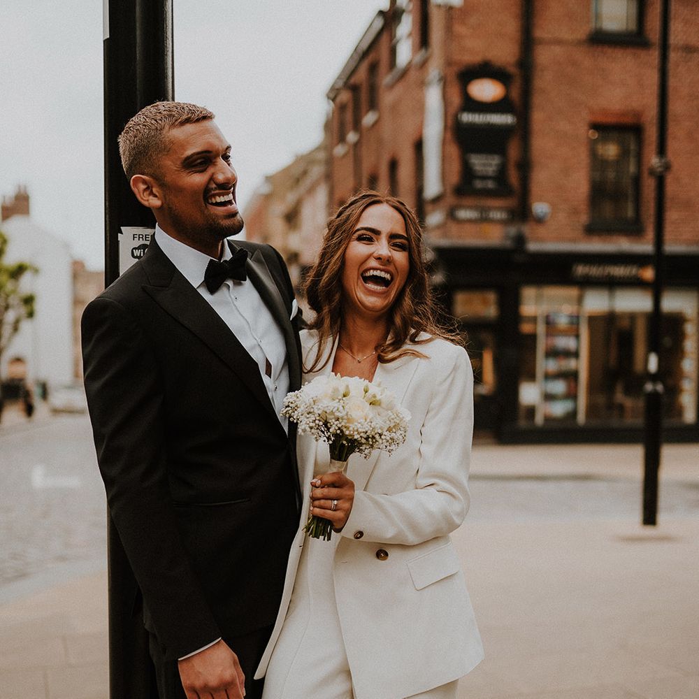 Bride and groom portrait in Sheffield with groom in a tuxedo and bride in a white three piece suit