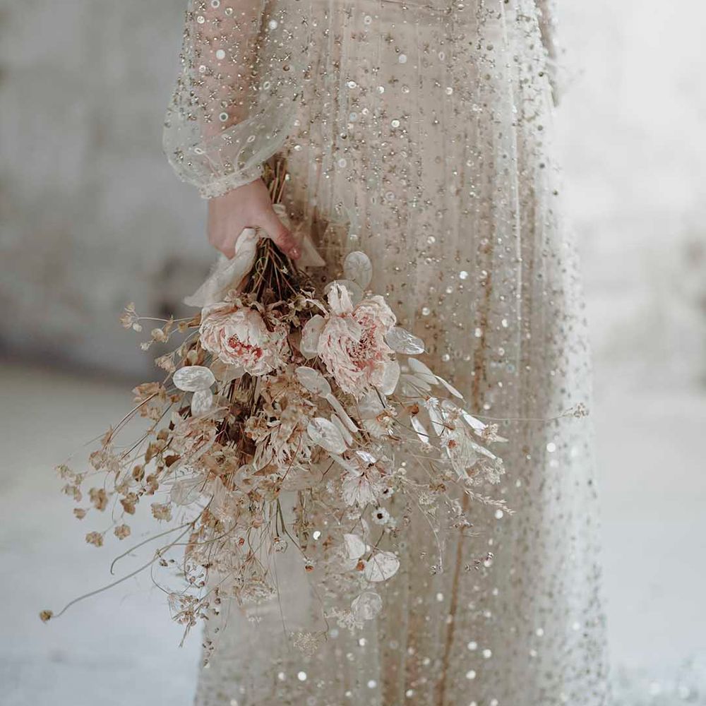 Bride in a sequin wedding dress holding a minimalist dried flower wedding bouquet 