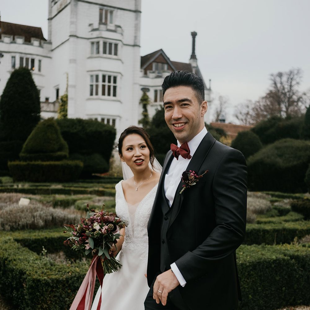 Bride and groom walk through the grounds of Danesfield House venue at Winter wedding