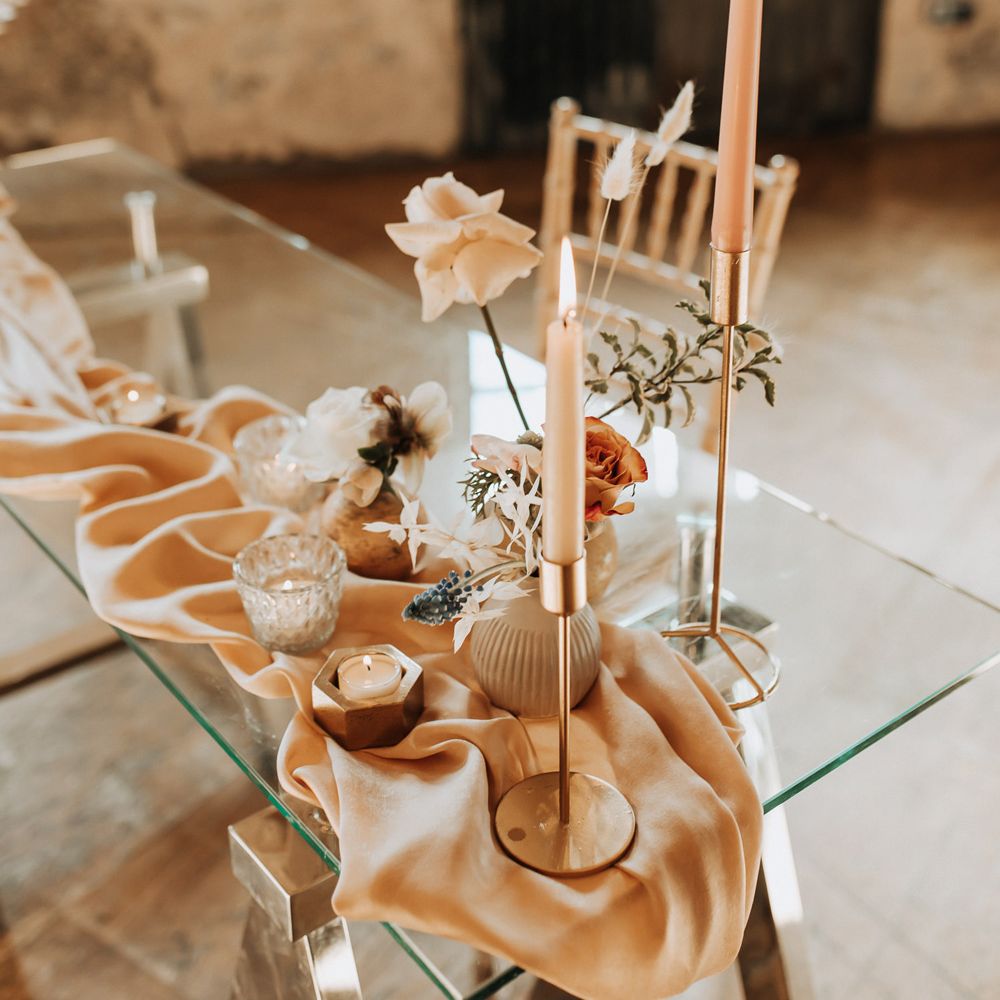 Glass wedding table with draping, pastel florals and pink dinner candles