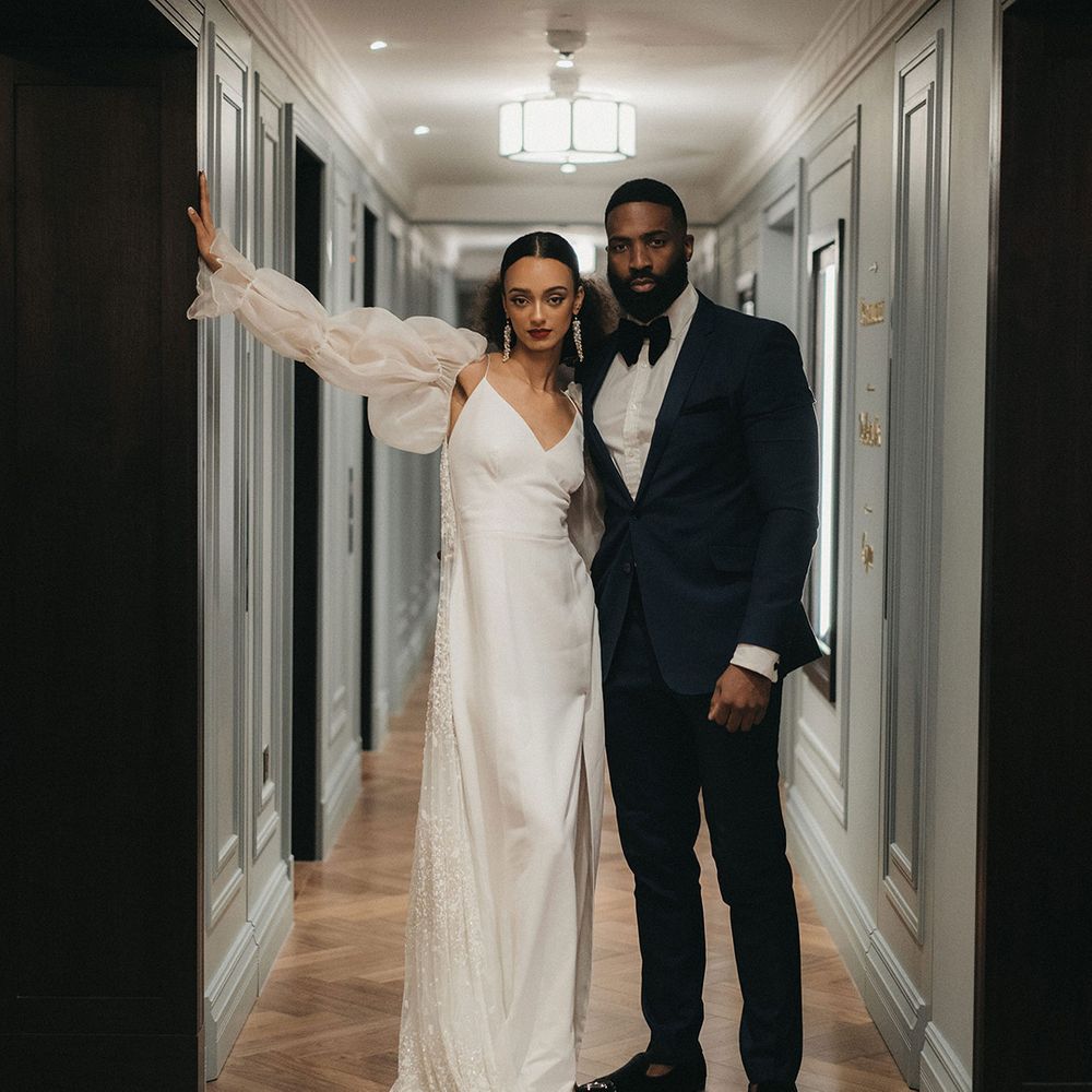 Black bride and groom at Mayfair Townhouse contemporary wedding with tuxedo suit and slip wedding dress