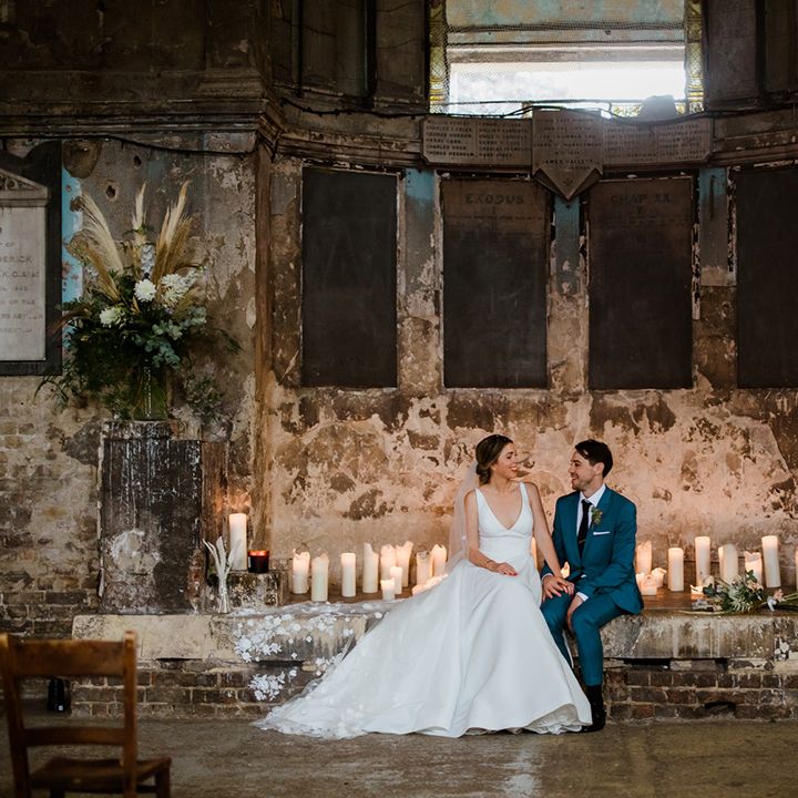 Bride and groom sit together at the altar of their industrial city wedding venue