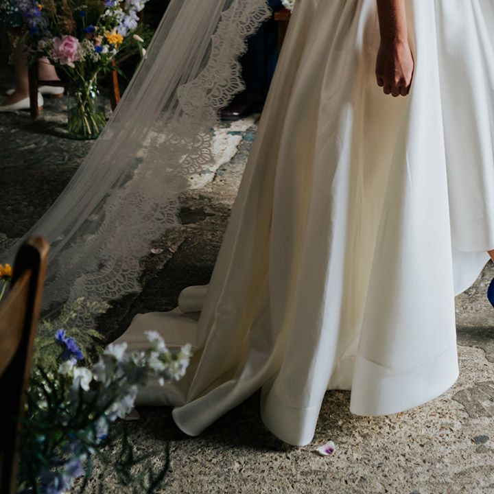 Bride in high low wedding skirt to show off electric blue wedding heels and long lace detail veil 