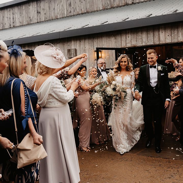 Bride and from exit wedding venue to wedding guests throwing confetti to celebrate the union