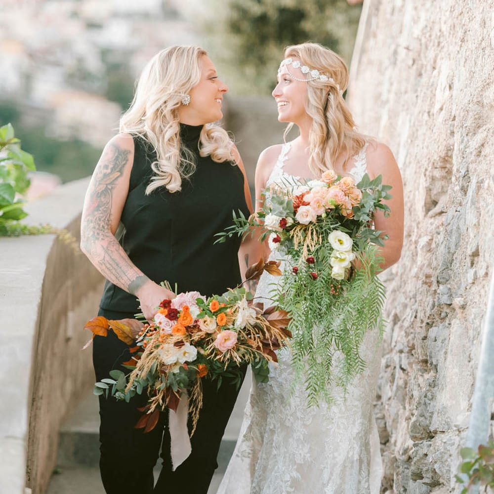 Newlyweds walking through the grounds of Hotel Marincanto after their LGBTQI+ wedding ceremony in Italy